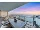 Relaxing balcony with a table and chairs, perfect for enjoying the beautiful water views at sunset at 1155 N Gulfstream Ave # 1205, Sarasota, FL 34236