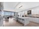 Open concept living space with modern kitchen featuring waterfall island, barstool seating, and seamless flow into dining and living area at 1155 N Gulfstream Ave # 1205, Sarasota, FL 34236
