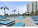 Luxury pool area with blue lounge chairs and palm trees offers a relaxing outdoor oasis at 1155 N Gulfstream Ave # 1205, Sarasota, FL 34236