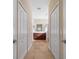 Hallway leading to well-lit bathroom with double sinks and vanity at 12140 Whisper Lake Dr, Bradenton, FL 34211