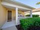 Inviting front porch with white pillars, a ceiling fan, a welcome mat, and lush landscaping at 12140 Whisper Lake Dr, Bradenton, FL 34211