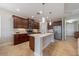 Well-lit kitchen with stainless steel refrigerator, island, and wood cabinets at 12140 Whisper Lake Dr, Bradenton, FL 34211