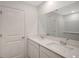 Modern bathroom featuring double sinks with quartz counters and a large mirror at 13026 Bayberry Way, Parrish, FL 34219