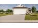 Charming home featuring a gray exterior, a wide garage door, a well-maintained lawn, and a concrete driveway at 13030 Bayberry Way, Parrish, FL 34219