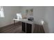 Bright home office with a modern white desk, ergonomic chair, and a large computer monitor, complemented by wood floors at 13030 Bayberry Way, Parrish, FL 34219