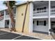 Condo exterior showing the building's facade, balconies, and landscaping with palm trees, and parking area at 1531 Pleasant Rd # H-3, Bradenton, FL 34207