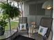 Inviting screened porch with chairs, decorative pillows, and hanging plants at 1531 Pleasant Rd # H-3, Bradenton, FL 34207