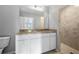 Bathroom featuring white cabinets, a tile shower, and granite countertops at 16267 Banyan Ave, Port Charlotte, FL 33954