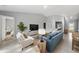 Cozy living room featuring modern decor, light gray walls, and tile floors, leading to a bedroom and the kitchen at 16267 Banyan Ave, Port Charlotte, FL 33954