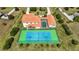 Stunning aerial view of home featuring a pristine tennis court, screened-in pool area, and well maintained landscaping at 17809 Howling Wolf Run, Parrish, FL 34219
