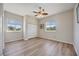 Inviting bedroom with wood-look floors, natural light from two windows, and closet at 17809 Howling Wolf Run, Parrish, FL 34219