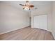 Bedroom with wood-look flooring, ceiling fan and closet at 17809 Howling Wolf Run, Parrish, FL 34219