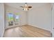 Inviting bedroom features wood-look flooring and French doors leading to a balcony at 17809 Howling Wolf Run, Parrish, FL 34219