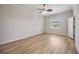 A light-filled bedroom featuring wood-look flooring, a ceiling fan, and neutral paint at 17809 Howling Wolf Run, Parrish, FL 34219