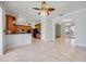Open kitchen with wood cabinetry, a breakfast bar, and views into the dining and living areas at 17809 Howling Wolf Run, Parrish, FL 34219