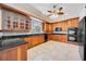 Bright kitchen featuring wooden cabinetry, black countertops, and stainless steel appliances at 17809 Howling Wolf Run, Parrish, FL 34219