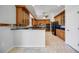 Spacious kitchen with tile flooring, wooden cabinets, black appliances, and a breakfast bar area at 17809 Howling Wolf Run, Parrish, FL 34219