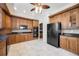 A kitchen showcasing wooden cabinets, black countertops, and modern appliances, including a refrigerator at 17809 Howling Wolf Run, Parrish, FL 34219