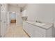 Bright laundry room with white cabinets, tile floor, and sink with ample counter space at 17809 Howling Wolf Run, Parrish, FL 34219