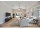 Bright living room with stylish furniture, a ceiling fan, and sliding glass doors to the pool area at 17809 Howling Wolf Run, Parrish, FL 34219