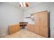 Office area with built-in wooden cabinetry, desk, and a ceiling fan at 17809 Howling Wolf Run, Parrish, FL 34219