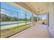 An outdoor patio featuring ceiling fan and string lights with a view of the community tennis court at 17809 Howling Wolf Run, Parrish, FL 34219