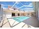 A beautiful swimming pool inside of a screened enclosure featuring tile border and a covered patio with seating at 17809 Howling Wolf Run, Parrish, FL 34219