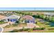 Aerial view showcases a single-story home, a brick driveway, a two-car garage and neighboring houses and ponds at 18115 Littleton Pl, Bradenton, FL 34202
