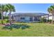 Expansive, private backyard with an enclosed pool, lush lawn, and tropical palm trees at 18115 Littleton Pl, Bradenton, FL 34202