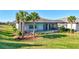 Inviting backyard featuring a screened-in lanai, tropical palm trees, and a pool and spa, perfect for entertaining at 18115 Littleton Pl, Bradenton, FL 34202