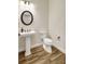 Stylish half-bath featuring a pedestal sink, decorative mirror, and modern fixtures at 18115 Littleton Pl, Bradenton, FL 34202