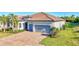 Attractive single-story home with a brick driveway leading to a two-car garage and well-maintained landscaping at 18115 Littleton Pl, Bradenton, FL 34202