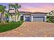 Beautiful single-story home showcasing lush landscaping and a paver driveway, complemented by a three-car garage at 18115 Littleton Pl, Bradenton, FL 34202