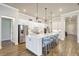Kitchen featuring white cabinets, stainless steel appliances, a large island, and stylish pendant lighting at 18115 Littleton Pl, Bradenton, FL 34202