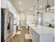 Modern kitchen with stainless steel appliances, white cabinetry, a large island, and wood-look tile flooring at 18115 Littleton Pl, Bradenton, FL 34202
