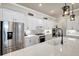Modern kitchen featuring stainless steel appliances, white cabinetry, quartz countertops, and stylish pendant lighting at 18115 Littleton Pl, Bradenton, FL 34202