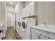 Laundry room featuring a washer, dryer, white cabinets, sink, and wood-look tile flooring at 18115 Littleton Pl, Bradenton, FL 34202