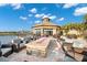 Inviting outdoor patio featuring comfortable seating around a fire pit with views of a pond and clubhouse at 18115 Littleton Pl, Bradenton, FL 34202
