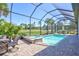 Screened-in pool and spa with brick patio and lush landscaping create a serene outdoor oasis at 18115 Littleton Pl, Bradenton, FL 34202