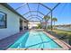 Relaxing backyard with a screened-in pool and hot tub overlooking a tranquil lake at 18115 Littleton Pl, Bradenton, FL 34202