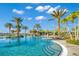 Beautiful resort-style pool with clear blue water, palm trees, lounge chairs, and tropical landscaping at 18115 Littleton Pl, Bradenton, FL 34202