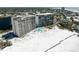 Aerial view of beachfront condos with swimming pool, beach access, and nearby city skyline at 20 Whispering Sands Dr # 301, Sarasota, FL 34242