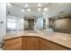 Bathroom with wood cabinets, granite countertop, mirrors and walk-in glass shower at 20 Whispering Sands Dr # 301, Sarasota, FL 34242