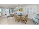 Open-concept dining area with a glass table and seating for six, adjoining the living room at 20 Whispering Sands Dr # 301, Sarasota, FL 34242