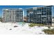 Beachfront condos featuring a swimming pool surrounded by palm trees and well-maintained landscaping at 20 Whispering Sands Dr # 301, Sarasota, FL 34242