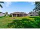 Green backyard with spacious screened-in porch, perfect for outdoor enjoyment at 2114 147Th E Ct, Bradenton, FL 34212