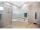 Bright bathroom featuring a soaking tub, glass-enclosed shower, and neutral tile at 2114 147Th E Ct, Bradenton, FL 34212