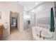Bright bathroom featuring a soaking tub, glass-enclosed shower, and neutral tile at 2114 147Th E Ct, Bradenton, FL 34212