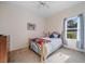 Cozy bedroom with a metal frame bed, ceiling fan and a bright window at 2114 147Th E Ct, Bradenton, FL 34212