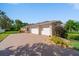 Beautiful home exterior boasting a three car garage, brick paver driveway and landscaped front yard at 2114 147Th E Ct, Bradenton, FL 34212